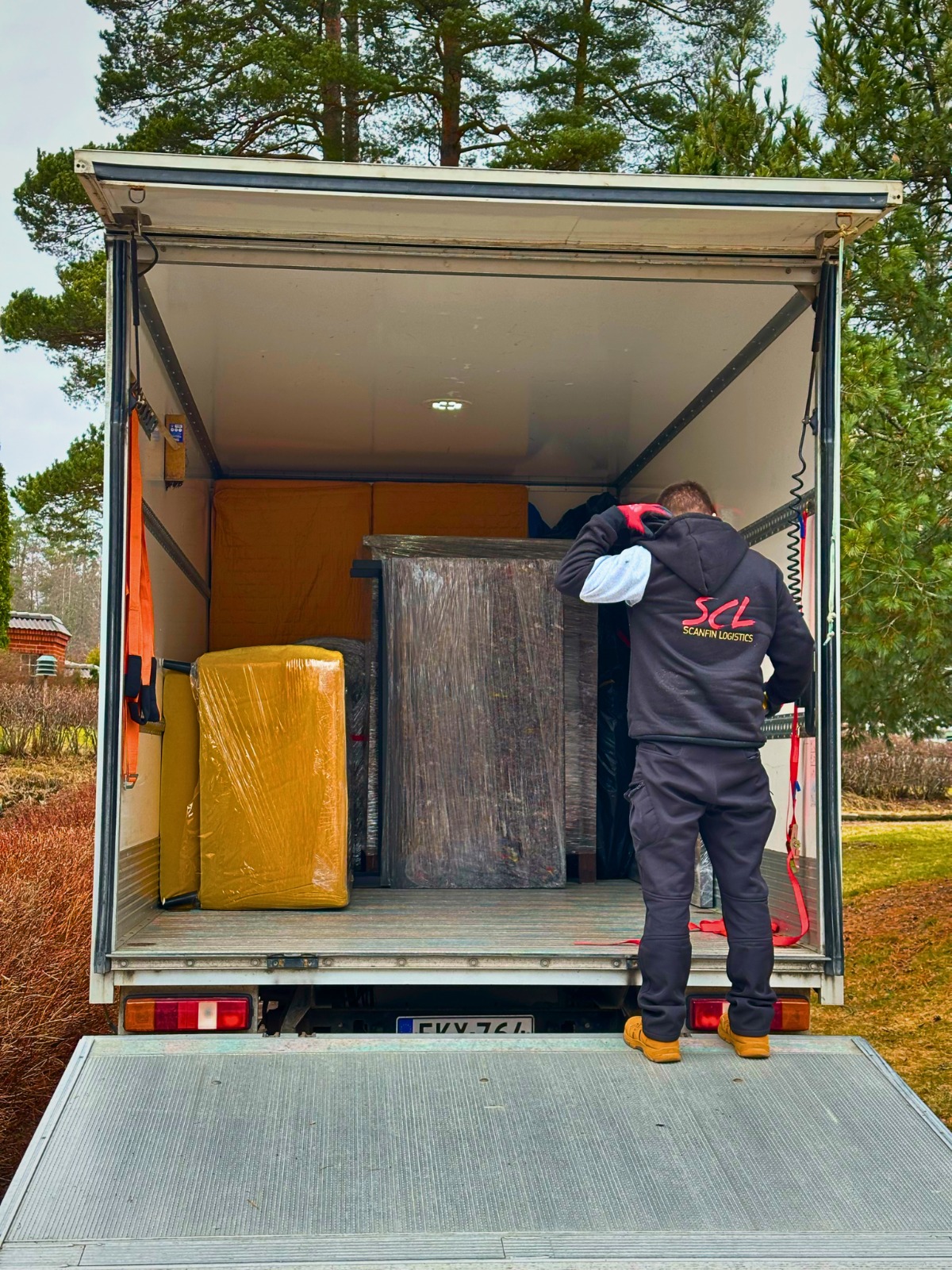 ScanFin Logisticsin työntekijä lastaa suojattuja tavaroita kuljetusautoon
